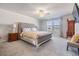 Spacious main bedroom with a tufted headboard bed, ceiling fan, and bright natural light at 6236 Dutton Dr, Wesley Chapel, FL 33545