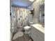 Bathroom featuring ocean-themed shower curtain, wood-look tile, white vanity, and decorative mirror at 6701 Medlar Dr, New Port Richey, FL 34653