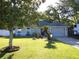 Charming single-story home featuring a well-manicured lawn and mature trees at 6701 Medlar Dr, New Port Richey, FL 34653