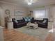 Bright living room featuring a large sectional sofa, decorative lamps, and coastal decor at 6701 Medlar Dr, New Port Richey, FL 34653