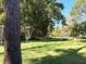 Lush backyard with mature trees, a swing set, and outdoor seating area perfect for relaxation at 6701 Medlar Dr, New Port Richey, FL 34653