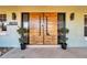 Features a modern, wood grain double-door entrance with black hardware, flanked by symmetrical planters at 8032 13Th S Ave, St Petersburg, FL 33707