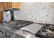 Close-up of kitchen stove with stainless steel accents and decorative backsplash at 8032 13Th S Ave, St Petersburg, FL 33707