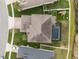 Aerial view of a home with a private screened-in pool, a lush backyard, and a driveway at 8141 Carlton Ridge Dr, Land O Lakes, FL 34638