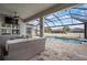 Screened-in lanai overlooking a backyard with a pool, a seating area, and a ceiling fan at 8141 Carlton Ridge Dr, Land O Lakes, FL 34638