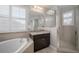 Bright bathroom featuring a soaking tub, shower, and dark wood vanity at 8141 Carlton Ridge Dr, Land O Lakes, FL 34638