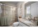 Well-lit bathroom featuring a tiled shower, granite countertop, and decorative art at 8141 Carlton Ridge Dr, Land O Lakes, FL 34638