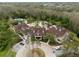 Aerial view of the clubhouse with pools, palm trees, and parking spots, a great place to relax at 8141 Carlton Ridge Dr, Land O Lakes, FL 34638