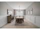 Elegant dining room boasts wainscoting, neutral colors, and a long table beneath a modern chandelier at 8141 Carlton Ridge Dr, Land O Lakes, FL 34638