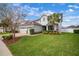 Beautiful home with a manicured lawn, mature trees, and a brick driveway, enhancing curb appeal and charm at 8141 Carlton Ridge Dr, Land O Lakes, FL 34638