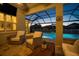 Covered patio with comfortable seating and a view of the pool and backyard, perfect for relaxing outdoors at 8141 Carlton Ridge Dr, Land O Lakes, FL 34638
