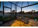 Relaxing screened patio with lounge chairs overlooking a backyard and play area at 8141 Carlton Ridge Dr, Land O Lakes, FL 34638