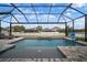 Screened-in pool with waterfall feature, lounge chairs, and basketball hoop offers a relaxing outdoor retreat at 8141 Carlton Ridge Dr, Land O Lakes, FL 34638