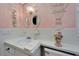 Bathroom features a clean, classic design with pink walls, vintage mirrors, and a white vanity at 8454 111Th St # 201, Seminole, FL 33772