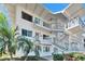 Exterior of a white condo building with lush palm trees and inviting outdoor staircases at 8454 111Th St # 201, Seminole, FL 33772