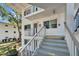 Exterior view of condo with stairs, a wreath, and a building adjacent in the background at 8454 111Th St # 201, Seminole, FL 33772