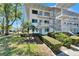 Three-story condo building featuring white exterior, lush greenery, and inviting staircases at 8454 111Th St # 201, Seminole, FL 33772