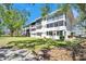 Bright white condominium building featuring screened-in lanais and lush landscaping at 8454 111Th St # 201, Seminole, FL 33772