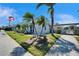 Exterior of building 8330 featuring palm trees, flagpoles, and lush landscaping at 8454 111Th St # 201, Seminole, FL 33772