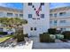White condo building featuring building number and balconies with bright blue sky in background at 8454 111Th St # 201, Seminole, FL 33772