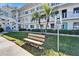 Condominium building entrance with teal doors, park bench and bus stop sign at 8454 111Th St # 201, Seminole, FL 33772