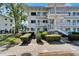 White condo building featuring well-maintained landscaping and inviting staircases at 8454 111Th St # 201, Seminole, FL 33772