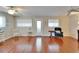 Bright living room featuring laminate wood floors, white trim, two windows and ceiling fans at 8454 111Th St # 201, Seminole, FL 33772