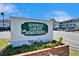 Seminole Garden Apartment complex sign with colorful flower beds and blue skies above at 8454 111Th St # 201, Seminole, FL 33772