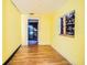 A bedroom with yellow walls features hardwood floors and a large window at 8719 N Ola Ave, Tampa, FL 33604
