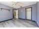 A bedroom with grey walls features new floors, closet, and a ceiling fan at 8719 N Ola Ave, Tampa, FL 33604
