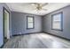 A bedroom with grey walls features new floors, ample natural light, and a ceiling fan at 8719 N Ola Ave, Tampa, FL 33604