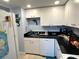 Efficient kitchen featuring white cabinetry, dark countertops, and modern appliances, maximizing space and functionality at 880 Mandalay Ave # S514, Clearwater Beach, FL 33767
