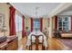 Formal dining room showcasing hardwood floors, a large table with seating, and bright windows with elegant red curtains at 9314 Heritage Oak Ct, Tampa, FL 33647