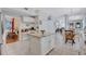 Open kitchen with granite island, white cabinets, stainless appliances, and an adjoining breakfast nook and living area at 9314 Heritage Oak Ct, Tampa, FL 33647