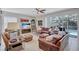Cozy living room with tile flooring, leather furniture, sliding glass doors to an outdoor pool at 9314 Heritage Oak Ct, Tampa, FL 33647