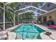 Beautiful in-ground pool enclosed with screen, with chairs and backyard landscaping at 9314 Heritage Oak Ct, Tampa, FL 33647