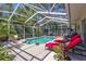 Enjoy the screened-in pool area with lounge chairs and tropical landscaping at 9314 Heritage Oak Ct, Tampa, FL 33647