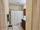 Neutral bathroom featuring tiled walls, a shower, and a vanity with dark wood cabinets at 100 Bluff View Dr # 117C, Belleair Bluffs, FL 33770