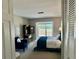 Bright bedroom with a private balcony, blue accents, and a dark wood armoire at 100 Bluff View Dr # 117C, Belleair Bluffs, FL 33770