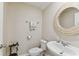 Powder room featuring a round mirror, vanity sink, and decorative towels at 1018 Rose Blossom Ct, Tampa, FL 33613