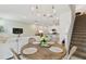 Open concept dining area with a round table, chandelier, and view into the kitchen and living room at 1018 Rose Blossom Ct, Tampa, FL 33613