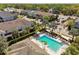 Aerial view of a community pool with lounge chairs, palm trees, and nearby homes at 1018 Rose Blossom Ct, Tampa, FL 33613