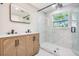 Bathroom featuring a wood vanity with double sinks and a glass enclosed shower at 1104 S Lois Ave, Tampa, FL 33629