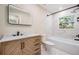 Bathroom showcasing a modern vanity, toilet, and a shower-tub combo with tiled walls at 1104 S Lois Ave, Tampa, FL 33629