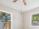 Bedroom featuring a ceiling fan and two windows providing natural light and outdoor views at 1104 S Lois Ave, Tampa, FL 33629