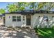 Well-maintained single-story house featuring a gray front door and manicured landscaping at 1104 S Lois Ave, Tampa, FL 33629