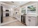 Bright, open kitchen with a wine fridge, white cabinetry, quartz countertops, and stainless steel appliances at 1104 S Lois Ave, Tampa, FL 33629