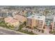 Aerial view of multi-story condo buildings, parking, a pool and nearby waterway at 11525 Gulf Blvd # 401, Treasure Island, FL 33706