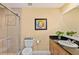 Bathroom featuring tile shower, framed mirror, vanity with dark countertop, and commode at 11525 Gulf Blvd # 401, Treasure Island, FL 33706