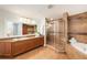 Bathroom featuring large vanity, granite countertops, glass enclosed shower, and soaking tub at 11525 Gulf Blvd # 401, Treasure Island, FL 33706